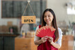 © Wasana - Asian female employee holding a red envelope or red envelope on Chinese New Year, a festive gift