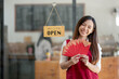 © Wasana - Asian female employee holding a red envelope or red envelope on Chinese New Year, a festive gift