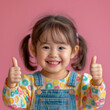 Fisheye view of a japanese kid girl jumping and thumbs pink background.