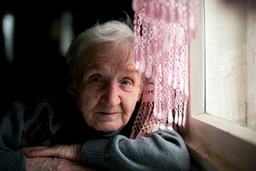 Wall Mural - Portrait of an elderly woman near a window.