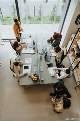 Sticker - An enthusiastic diverse team of coworkers collaborating in an innovative indoor office, discussing profitable strategies for their successful startup.