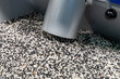 © hodim - Raw materials for the production of plastic products. An injection molding machine hopper filled with black and white polymer granules. Molding of plastic products