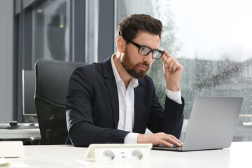 Canvas Print - Man working on laptop at white desk in office