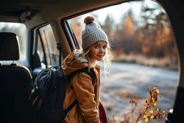 Canvas Print - A young girl bundled up in winter clothing gazes out from the passenger seat of a car, her hat and jacket keeping her warm as she takes in the outdoor scenery