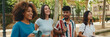 © Andrii Nekrasov - Happy multiethnic young people walk embracing on summer day outdoors, Panorama. Group of friends are talking and laughing merrily while walking along on the street