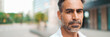 © Andrii Nekrasov - Close-up Businessman mature with neat beard wearing white shirt looks turns his head at the camera in the financial district in the city, Panorama