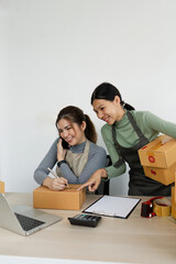 Asian woman write parcel box to prepare for delivery to customer. e-business concept