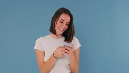Young woman use mobile cell phone typing browsing chatting send sms isolated on blue background 