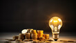 Light bulb with a stack of coins. Dark background with copy space - 16:9 format