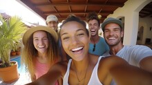 Young Tourists Of Different Races Are Enjoying Their Stay At A Hostel While Booking A Summer Vacation Home. They Capture Memories With A Fun Group Selfie During Their Holiday Getaway.