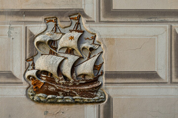 Wall Mural - Bas relief of a caravel,  sailing ship used by the Portuguese for the oceanic exploration voyages during the Age of Discovery (15-16th c.), on a wall