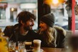 A pair of lovers share a moment of intimacy over a steaming cup of coffee, their eyes locked in a passionate gaze as they sit at a cozy table in a bustling coffeehouse on a busy street, their clothin