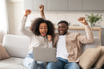 Wall Mural - Joyful African American Couple With Laptop Gesturing Yes At Home