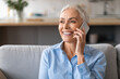 © Prostock-studio - Portrait shot of happy mature lady talking on cellphone indoors