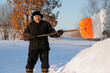 © Parilov - Elderly man cleaning snow with shovel in village after snowstorm, pensioner works as janitor