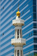 Wall Mural - Minarete de mezquita frente a rascacielos en Abu Dhabi, Emiratos Árabes Unidos