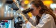 Woman in Lab Coat Examining Specimen Through Microscope