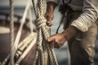 Close-up shot of a person tying a rope on a boat. Perfect for illustrating boating activities and maritime adventures