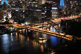Fototapeta Nowy Jork - Downtown at night. View of the city lights and landscape. Panoramic view of the bridge and river in the downtown city of Pittsburgh, Pennsylvania —aerial, birds' eye view of downtown and river.