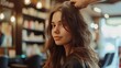 A young beautiful girl hairdresser does the hair of a beautiful brunette in a beauty salon