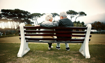 Canvas Print - Hug, bench or old couple in park or nature talking or bonding together in retirement outdoors back view. Senior, elderly man or mature woman on date to relax with love, peace or care on calm holiday