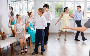 Wall Mural - Boy invites girl to dance paired ballroom waltz dance in studio