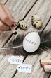 © ADDICTIVE STOCK - Person stamping 'Easter' on egg with tags 'Happy Eggs'