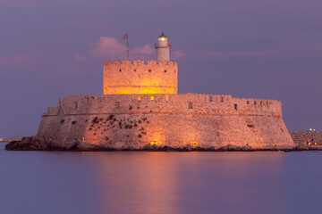 Wall Mural - Old stone lighthouse in Fort St. Nicholas in Rhodes at sunset.