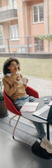 Wall Mural - Smiling woman entrepreneur working on laptop, making notes in cozy coworking space interior