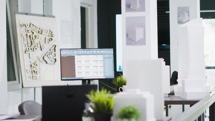 Cad architecture software on computer at empty office desk, urbanistic project plans and blueprints placed on table. Modern engineering unicorn business workstations with industrial tools.