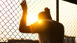 Silhouette of a man behind the fence, Silhouette photo of  feeling upset, sad, unhappy or disappoint crying. Young people mental health care problem lifestyle concept, frustrated standing hopelessly