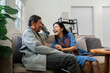 © itchaznong - Older couples sit and chat and head over each other relaxed and happy on sofa at home on weekday in comfortable