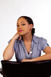 Young Attractive Mixed Woman Sitting With Arms On Back Of Chair