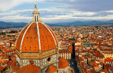 Fototapeta Uliczki - The majestic dome of Cathedral Santa Maria del Fiore overlooks the old town of Florence~Florence's cathedral stands out in the city with its beautiful Renaissance dome designed by Filippo Brunelleschi