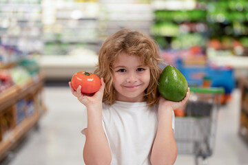 Wall Mural - Child choosing vegetables in supermarket store. Kids in food supermarket. Sales, discounts in food supermarket store and shopping. Kid in market bay vegetables and fruits. Child buy in supermarket.