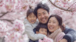 満開の桜の花の中で日本の家族4人が楽しそうに笑顔で自撮りしている写真、お花見