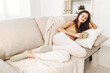 © SHOTPRIME STUDIO - Cozy Morning in a Warm Autumn Room: Mug-Holding Woman Drinking Coffee on a Sofa with a Blanket