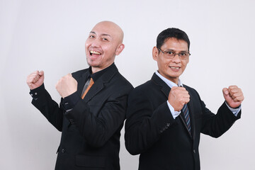 Two Asian businessmen raising hands and rejoicing in increasing profits.