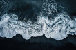 Aerial view of waves crashing on a black sand beach in Iceland. Background image. Created with Generative AI technology