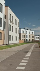 Wall Mural - Vertical establishing shot of street with modern two-storey and three-storey apartment buildings on sunny day