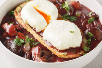 Sticker - Oeufs en meurette Poached eggs in a red wine sauce with pearl onions, mushrooms and bacon closeup on the plate on the table. Horizontal