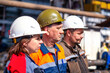 © Евгений Панов - Professional team and portrait of an engineer standing in a group of out-of-focus workers at an industrial manufacturing factory. They workat at metallurgical or oil refinery plant.Inspection check.