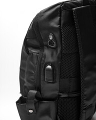 black backpack with side pocket, USB charging connector and wire hole