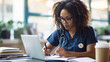 © MP Studio - female medical professional wearing scrubs and glasses, focused on writing notes in a book