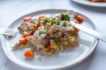 Wall Mural - Healthy fish dish with pan fried natural fish fillet with brown rice and vegetables on a plate