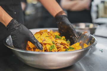 chef Cooking of crispy corn chips nachos at the restaurant kitchen