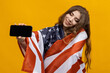 © makedonski2015 - A woman with a flag on her shoulders holds a smartphone. Placing ads on the phone screen. Yellow background