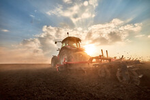 Tractor Plowing Field At Sunset