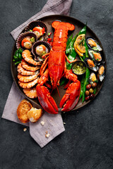 Canvas Print - Big red lobster on plate with shrimp and mussels with lemon, souce pesto and bread. Seafood concept