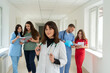 © RomanR - Group of medical team studetns or young doctors in uniform  in college hallway